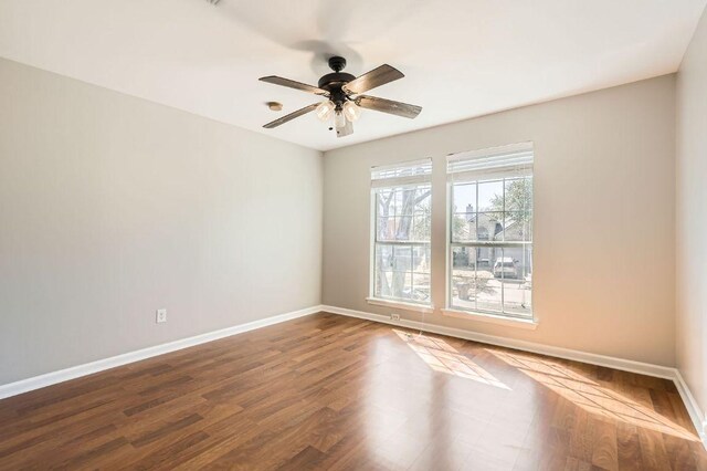 unfurnished room with dark wood-type flooring, baseboards, and ceiling fan