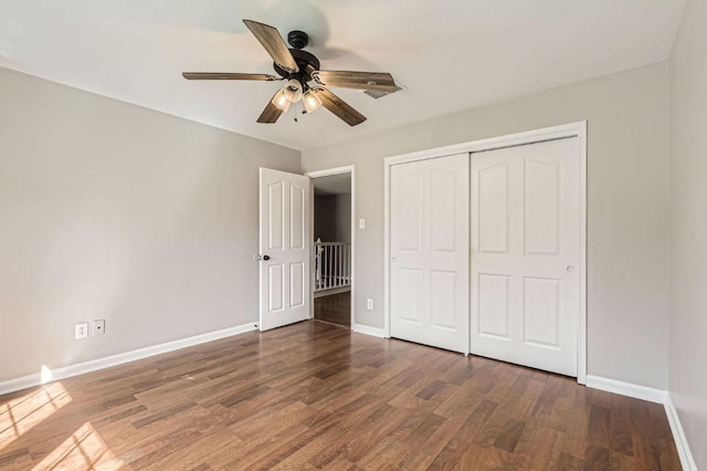 unfurnished bedroom with a ceiling fan, wood finished floors, baseboards, and a closet