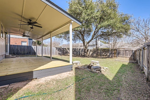 view of yard with a fenced backyard, a wooden deck, and ceiling fan