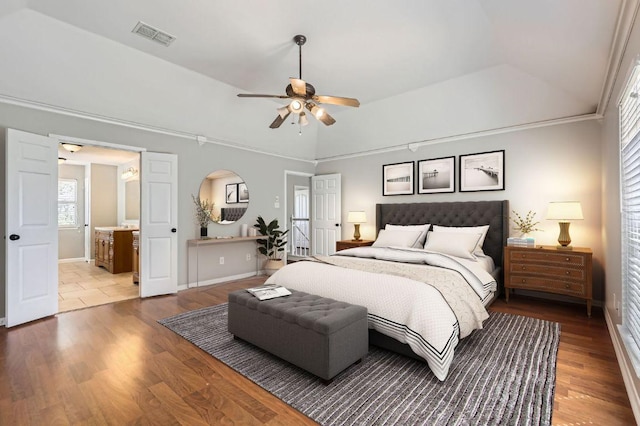 bedroom featuring ensuite bath, wood finished floors, visible vents, and baseboards