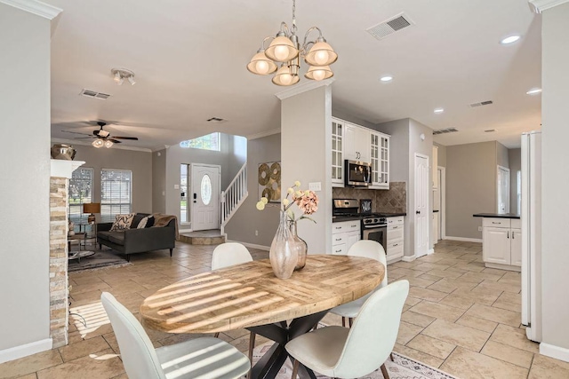 1703 Pecos Valley Cv, Round Rock, TX 78665 - dining space featuring baseboards, ceiling fan, stairs, a chandelier, and ornamental molding