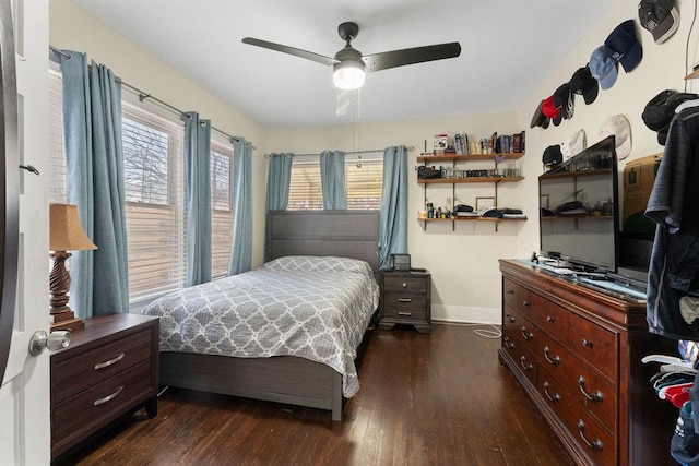 bedroom with ceiling fan, baseboards, multiple windows, and dark wood finished floors