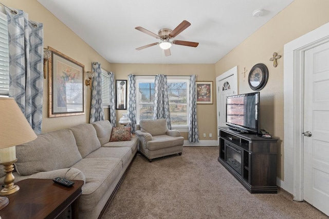 carpeted living room with baseboards and a ceiling fan