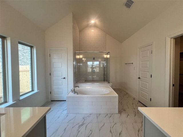 20425 Gillbrand Rd, Manor, TX 78653 - bathroom with marble look tile flooring, lofted ceiling, a garden tub, and a tile shower