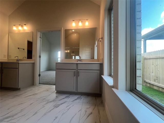 20425 Gillbrand Rd, Manor, TX 78653 - full bath featuring two vanities, marble look tile flooring, and lofted ceiling