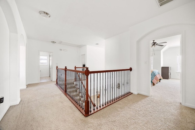 hallway with visible vents, attic access, baseboards, and carpet floors