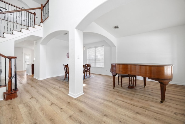 interior space with light wood-type flooring, visible vents, baseboards, and stairway