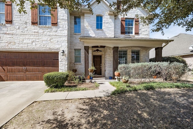 view of front of house featuring stone siding, driveway, and a garage