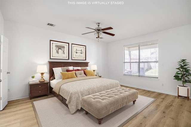 bedroom featuring a ceiling fan, light wood-style floors, visible vents, and baseboards