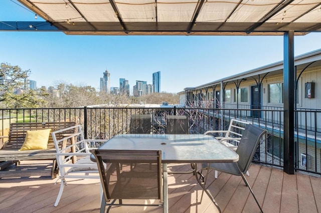 deck featuring outdoor dining space and a view of city