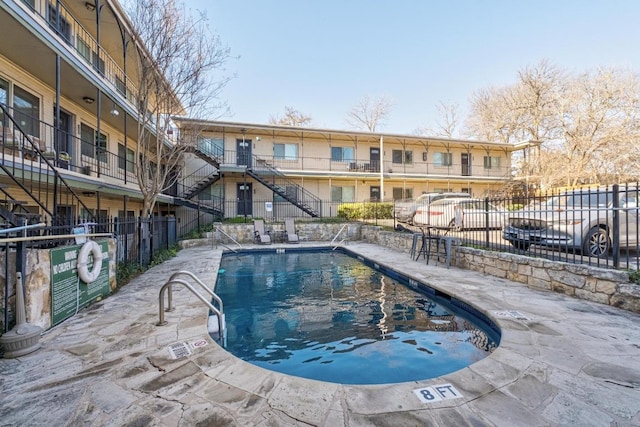 pool with a patio area and fence