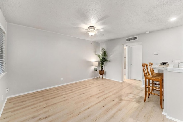 dining room featuring visible vents, baseboards, ceiling fan, wood finished floors, and a textured ceiling