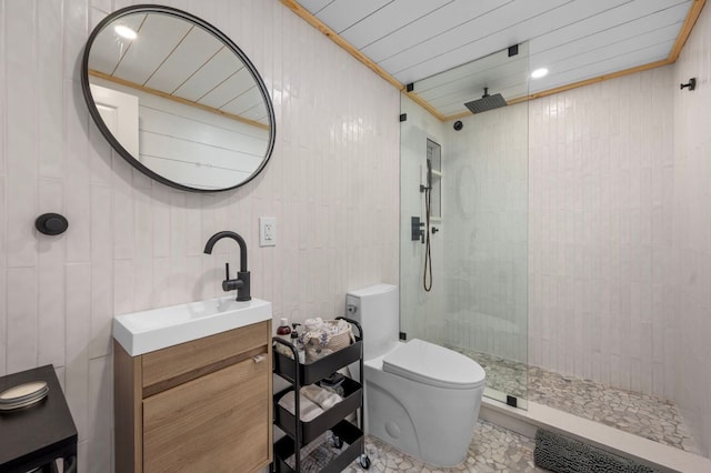 bathroom featuring toilet, ornamental molding, a walk in shower, tile walls, and vanity