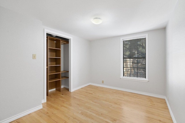 unfurnished bedroom featuring light wood-style flooring and baseboards