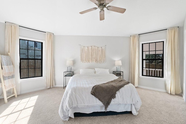 carpeted bedroom with baseboards, multiple windows, and a ceiling fan