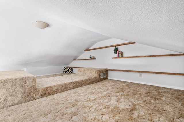 additional living space with lofted ceiling, carpet, visible vents, and a textured ceiling