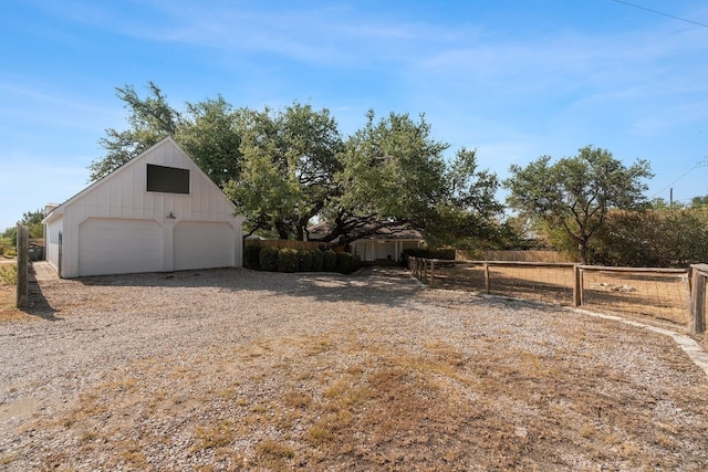 view of yard featuring a garage, an outdoor structure, and fence