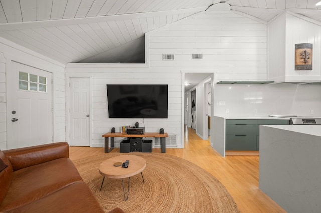 living room with lofted ceiling with beams, light wood-type flooring, and visible vents