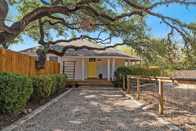 view of front of home featuring covered porch and fence private yard