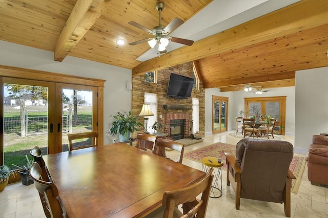 dining space with french doors, a brick fireplace, wooden ceiling, and vaulted ceiling with beams