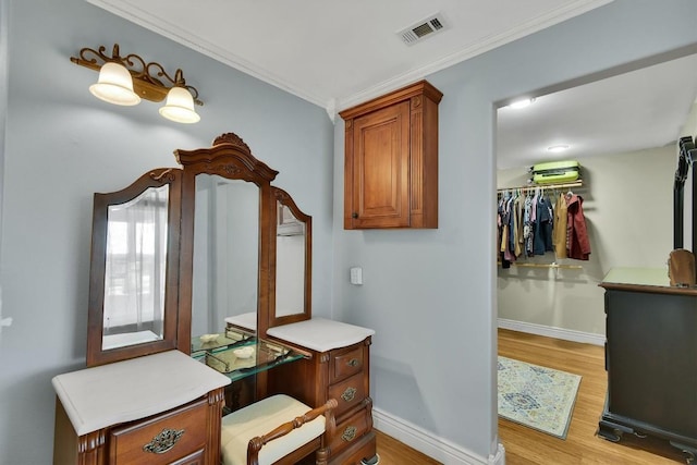 bathroom featuring visible vents, crown molding, baseboards, and wood finished floors