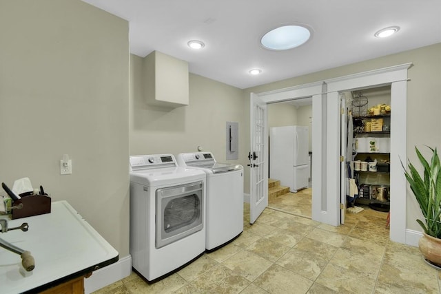 clothes washing area with a sink, baseboards, separate washer and dryer, and laundry area