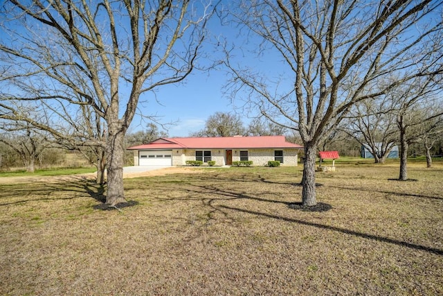 ranch-style home featuring a front lawn, concrete driveway, and an attached garage