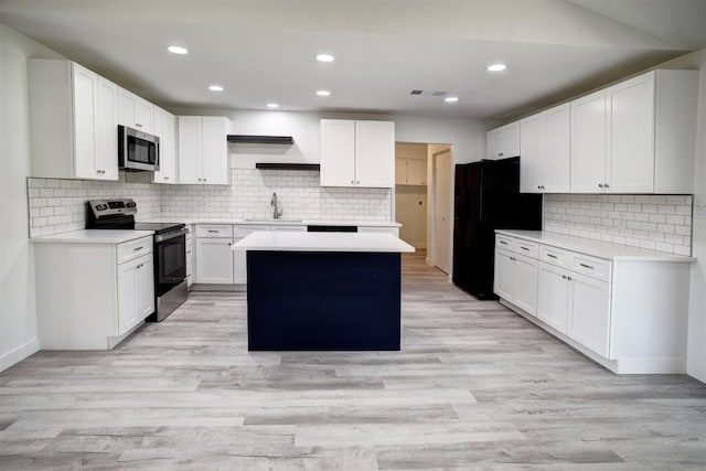 kitchen with open shelves, light wood-style flooring, a sink, appliances with stainless steel finishes, and a center island