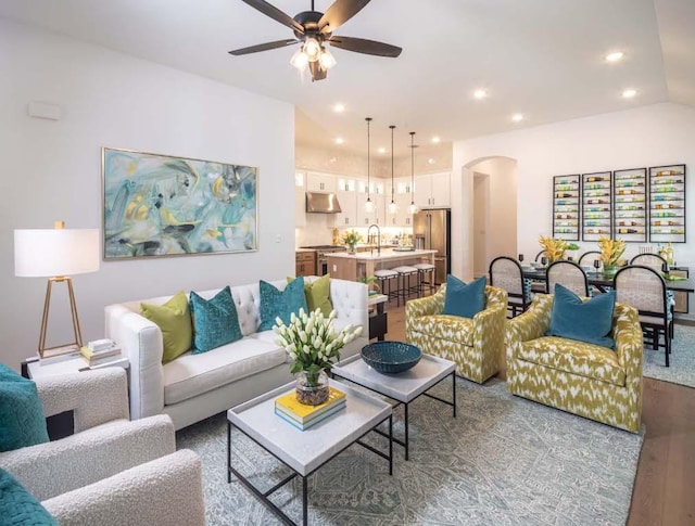 living room with recessed lighting, wood finished floors, arched walkways, and ceiling fan