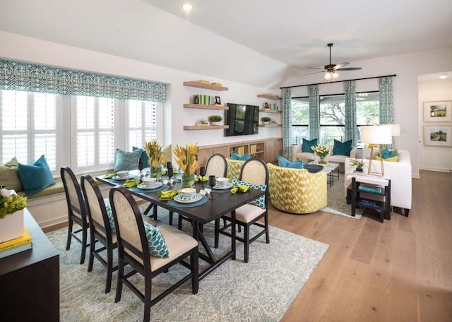 dining space with ceiling fan, plenty of natural light, lofted ceiling, and wood finished floors