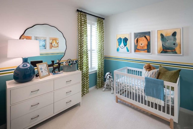 bedroom featuring light carpet, baseboards, and a nursery area