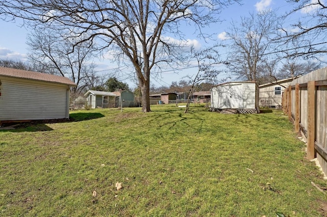 view of yard featuring an outdoor structure, a storage unit, and fence