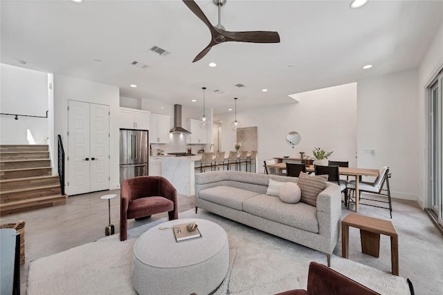 living area featuring stairs, recessed lighting, finished concrete flooring, and visible vents