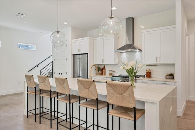 kitchen with visible vents, high quality fridge, wall chimney range hood, and decorative backsplash