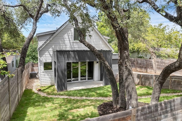 rear view of house featuring a patio, a fenced backyard, and a lawn