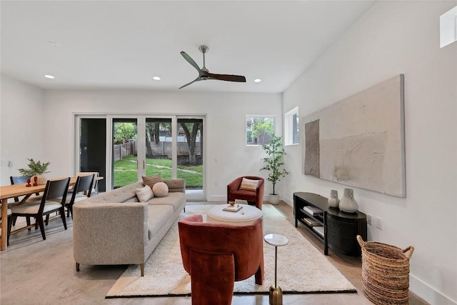 living area with recessed lighting, baseboards, concrete flooring, and ceiling fan