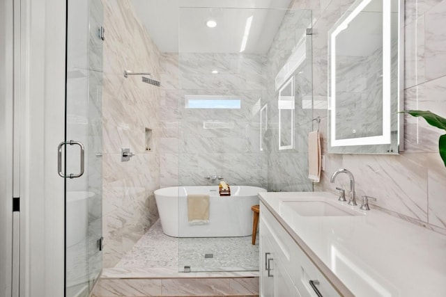 bathroom with a freestanding tub, tile walls, a shower stall, and vanity