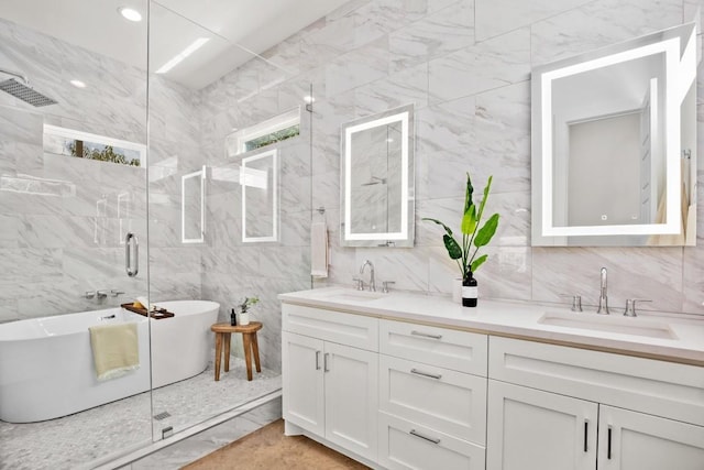 bathroom with double vanity, a soaking tub, a shower stall, and a sink