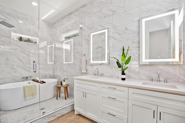 full bathroom featuring tile walls, double vanity, a shower stall, a freestanding tub, and backsplash