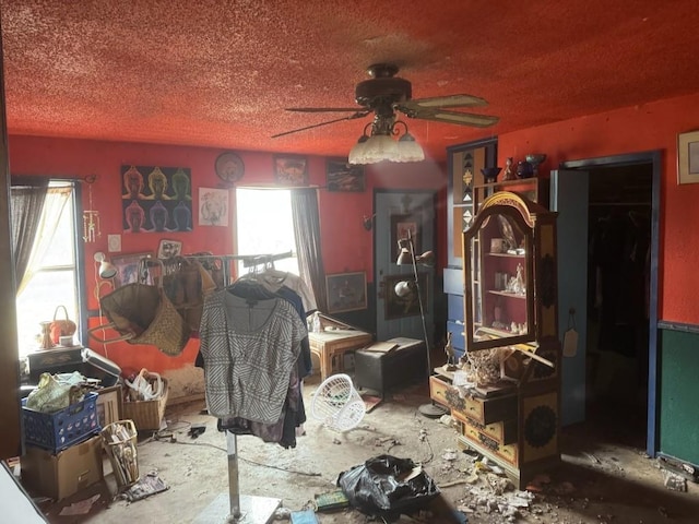 miscellaneous room with a textured ceiling and ceiling fan