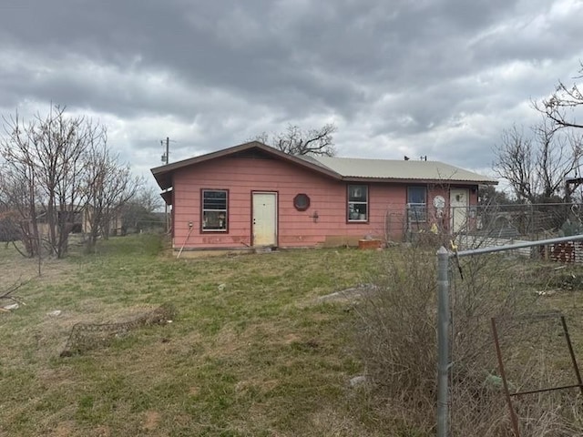 view of front facade with a front lawn and fence