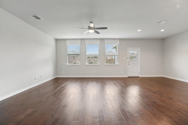 spare room featuring dark wood finished floors, baseboards, visible vents, and ceiling fan