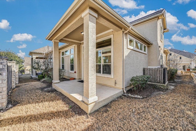 rear view of property featuring stucco siding and a patio