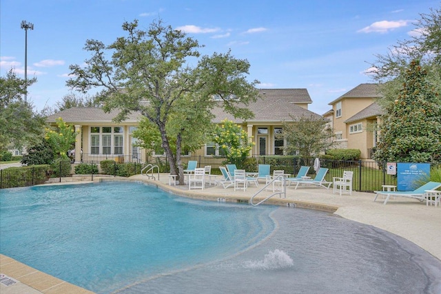 pool with a patio area and fence