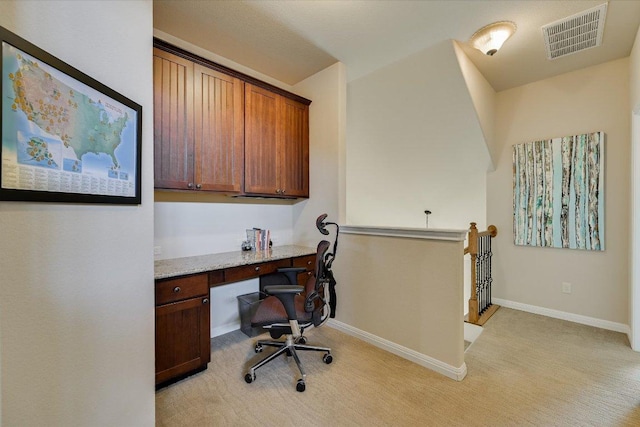 office area with baseboards, visible vents, and built in study area