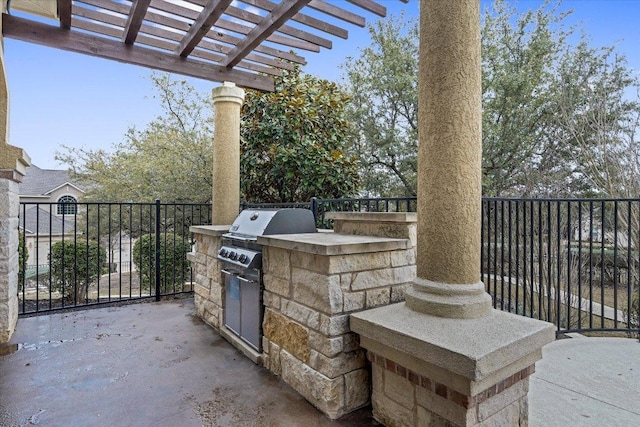 view of patio featuring fence, exterior kitchen, and a pergola