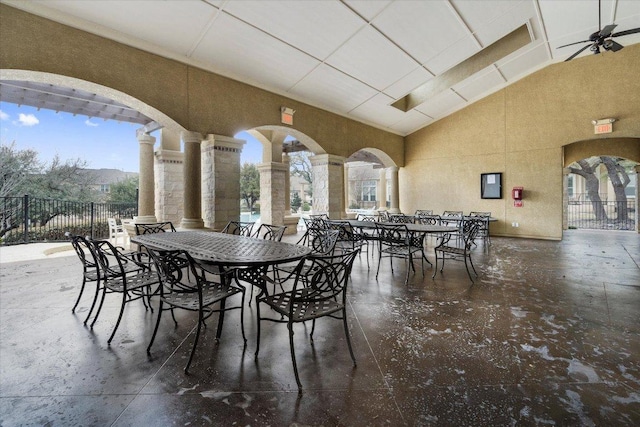 dining area with ceiling fan, plenty of natural light, decorative columns, and high vaulted ceiling