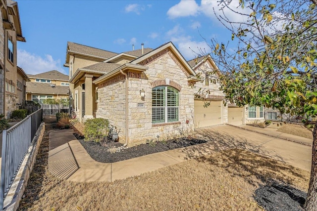 view of home's exterior featuring an attached garage, fence, roof with shingles, stone siding, and driveway