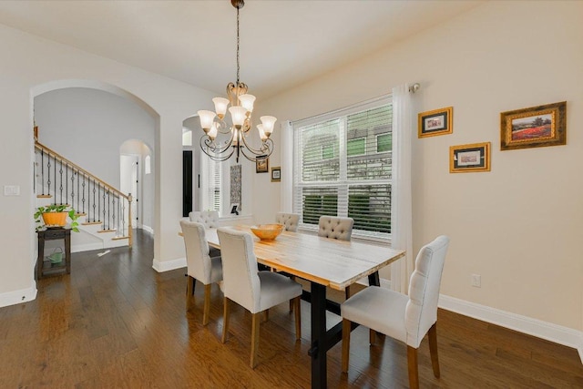 dining space with stairway, baseboards, arched walkways, and dark wood finished floors