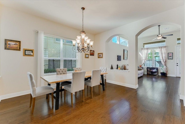 dining area with visible vents, ceiling fan with notable chandelier, dark wood finished floors, arched walkways, and baseboards